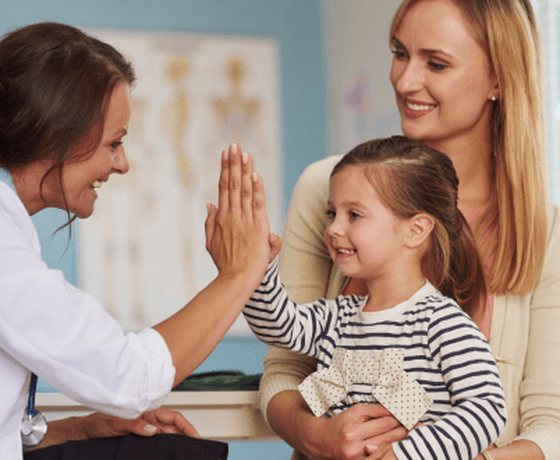A doctor giving a happy child a high five