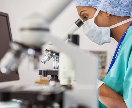 A laboratory specialist working with a microscope